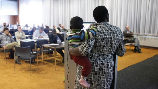 Speaker with baby presenting at IRC symposium