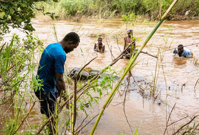 Tafadzwa going into the river to record a story on gold panning