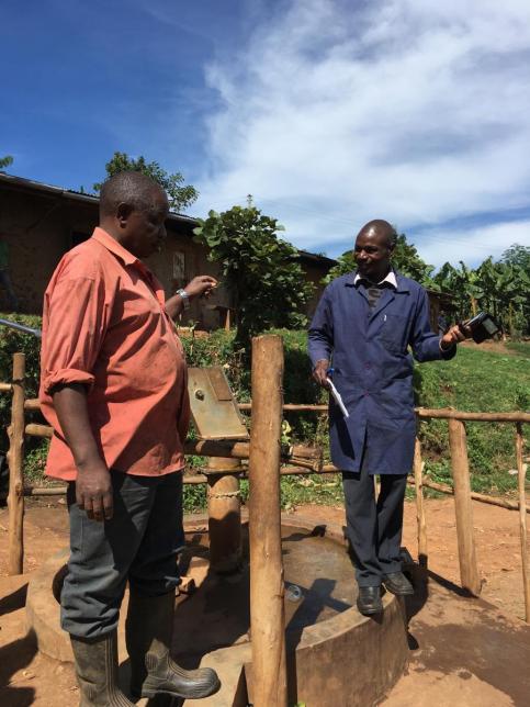 Stephen Balyabuga of KAHASA talks with the Burungu Water User Committee Chairperson (Photo by Caleb Cord)