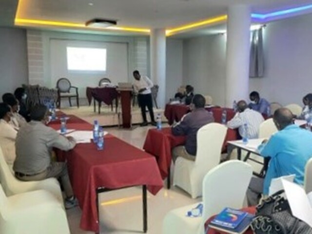 Picture of meeting with participants facing a speaker at the front of a room