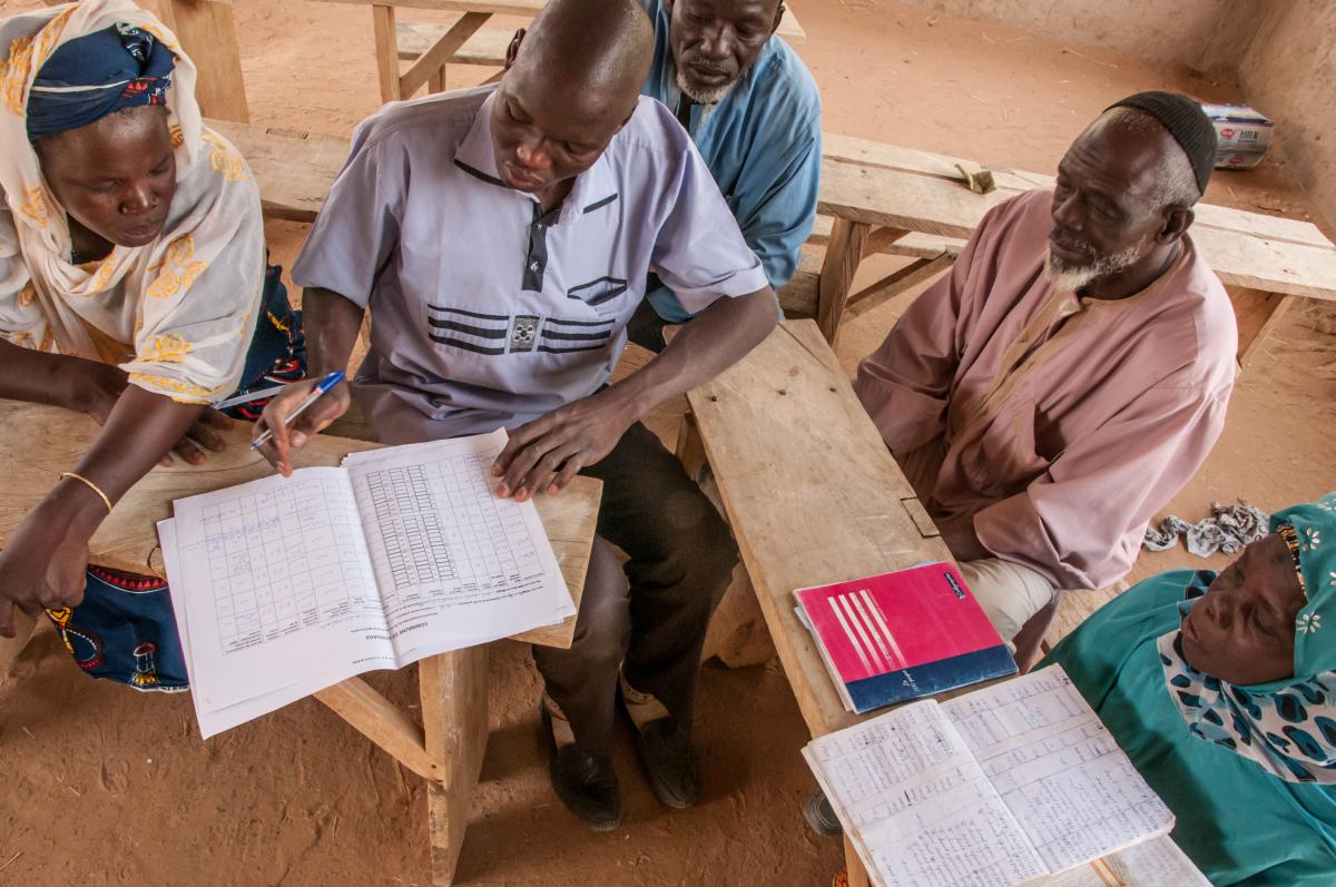 Ahmadou Abdoulaye Dicko, president of the Water Users Association of Gorgadji community (Burkina Faso), is collecting and noting down water user payments. Photo:IRC